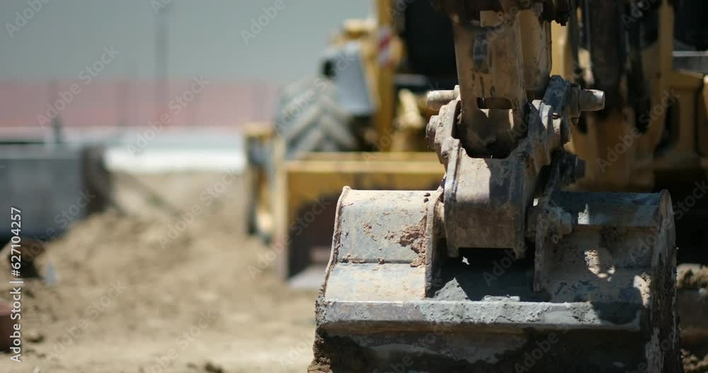 Heavy earthmovers wait at a construction site for a railway project, part of infrastructure development in California. Heavy earthmovers wait at a construction site for a railway project, part of infrastructure development in California.