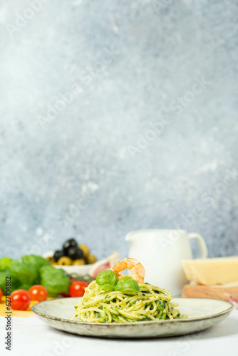 Detox Buddha bowl with avocado, spinach, greens, zucchini noodles, grilled shrimps and pesto sauce.