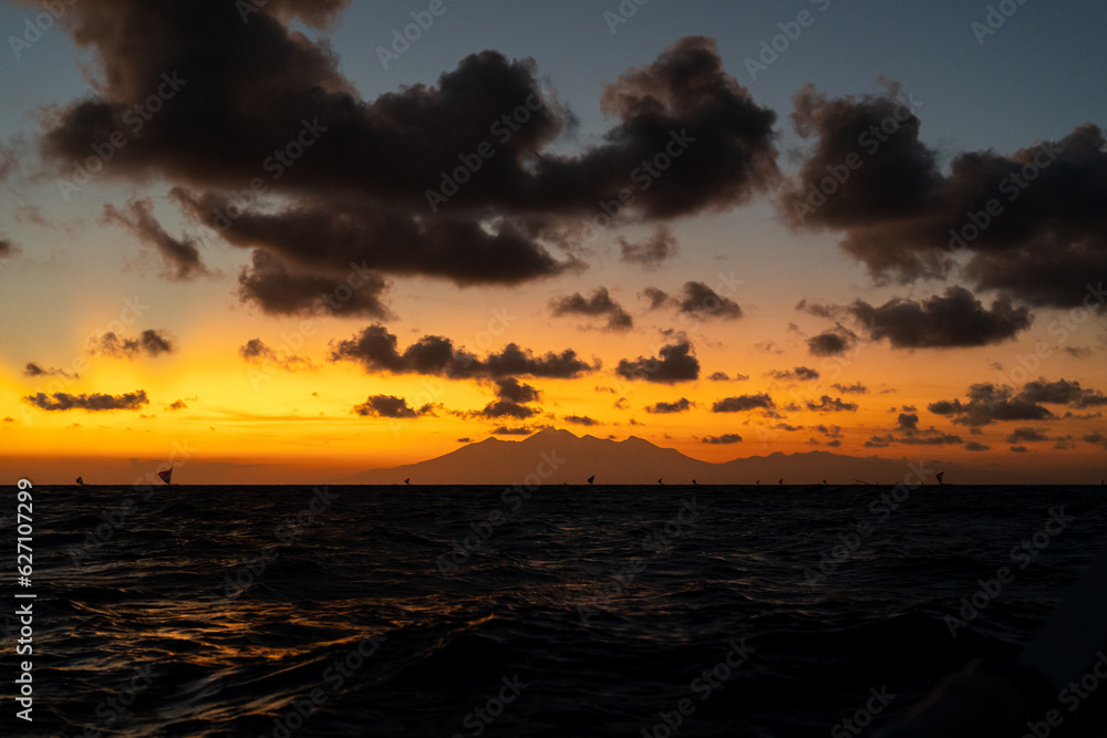 Obraz premium Mit den Fischern draußen im Morgengrauen vor der Küste von Bali mit Sonnenaufgang und Blick auf die Nachbarinsel Lombok