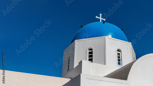 White traditional church with blue dome in Santorini island, Greece.