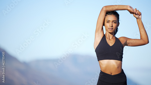 Woman stretching arms, fitness and portrait with sky background, exercise outdoor with mockup space and determination. Female athlete with confidence, warm up for workout and healthy active lifestyle