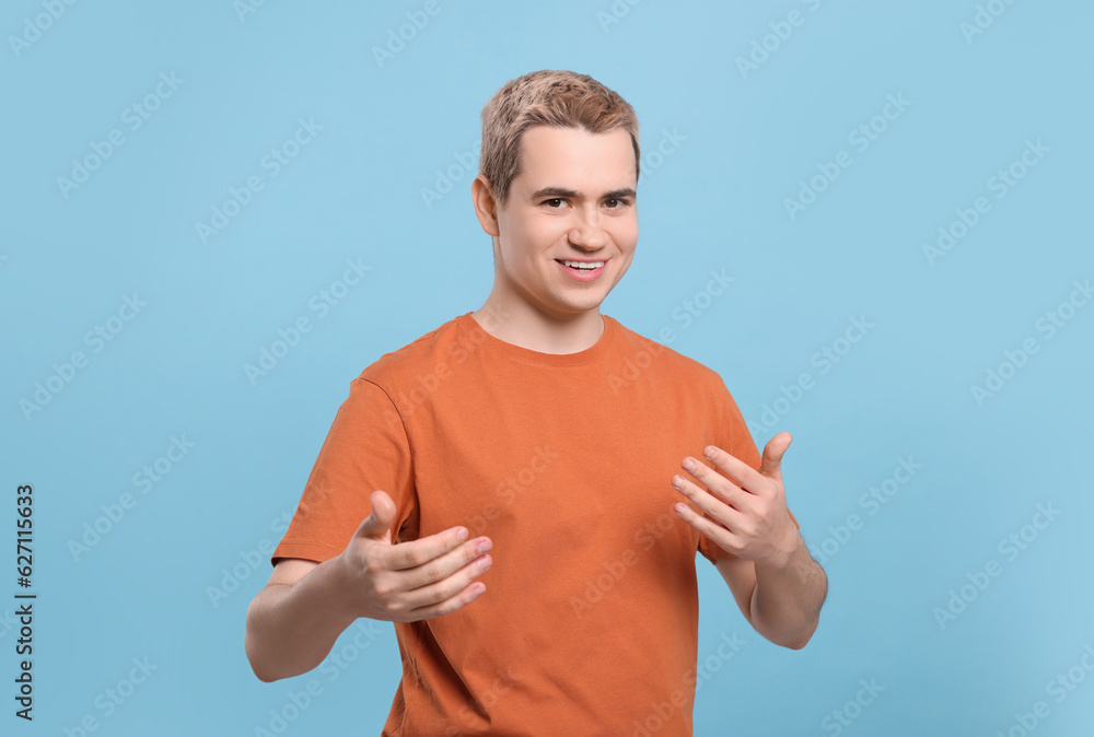 Happy man inviting to come in against light blue background Happy man inviting to come in against light blue background