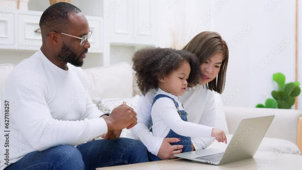 Happy african family parents and little children enjoy using computer laptop together sit on sofa, technology addicted couple with kids having fun at home Happy african family parents and little children enjoy using computer laptop together sit on sofa, technology addicted couple with kids having fun at home