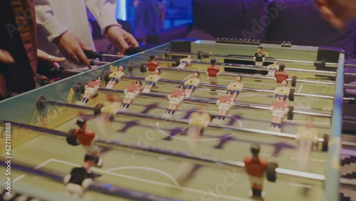 Wallpaper Mural Close-up slowmo shot of anonymous young woman and man playing table football at student party at home in blue neon light Torontodigital.ca