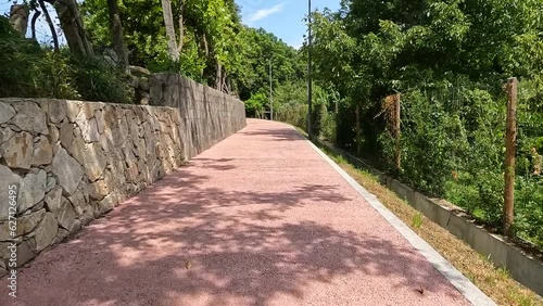 Point of view shot of riding a bicycle in Ecovia do Arda at Arouca, Portugal. Features a wide view of the bike track and the natural scenery. photo