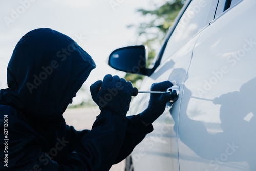 Close-up car thief hand holding screwdriver tamper yank and glove black. Man robber checking breaking entering alarm in a car stealing. Image about reflect society. photo