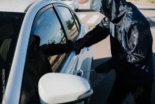 Close-up car thief hand holding screwdriver tamper yank and glove black. Man robber checking breaking entering alarm in a car stealing. Image about reflect society.