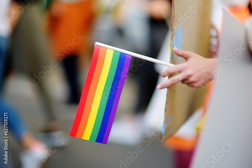 Activist holding rainbow flag and banner on the march on the city street during the Lgbt Pride Parade. Fighting for equality os sexual minorities.