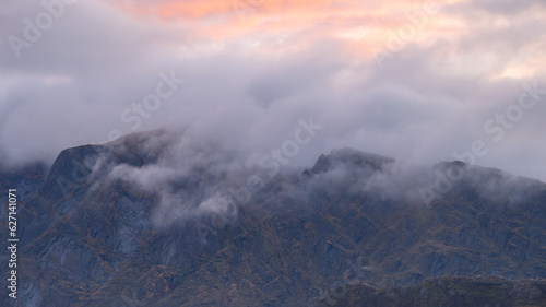 Orange morning sunlight with white clouds over the lime rocks mountain. For uuse as background