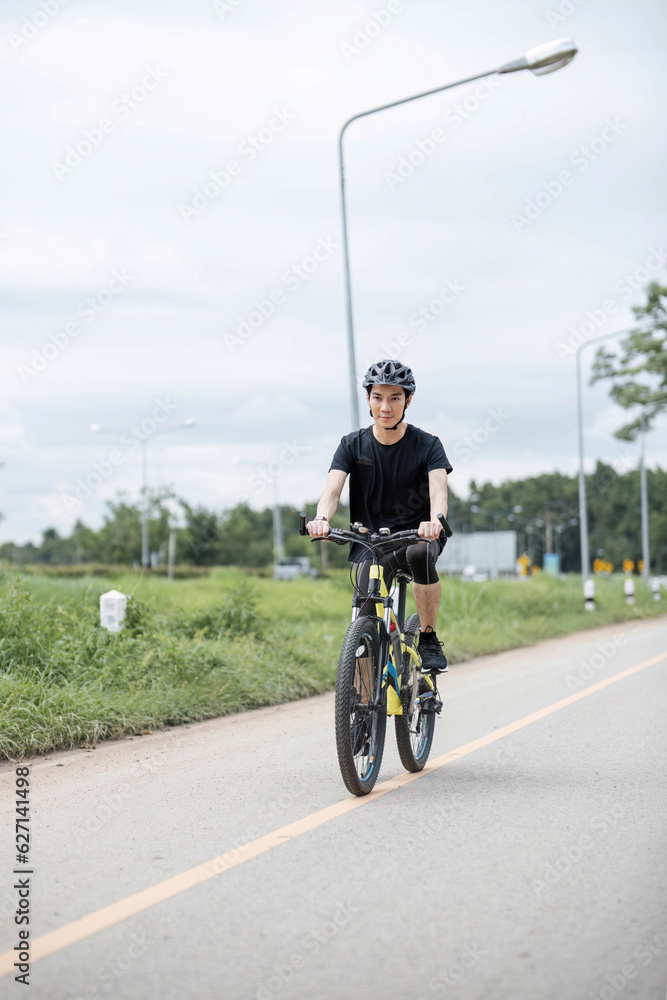 Obraz premium Shot of happy asian guy enjoying biking in the summer park. Sport, leisure and healthy lifestyle concept