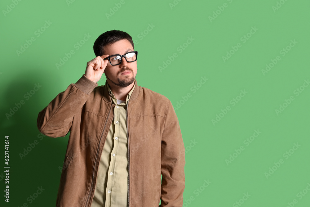 Obraz premium Handsome man in stylish eyeglasses on green background