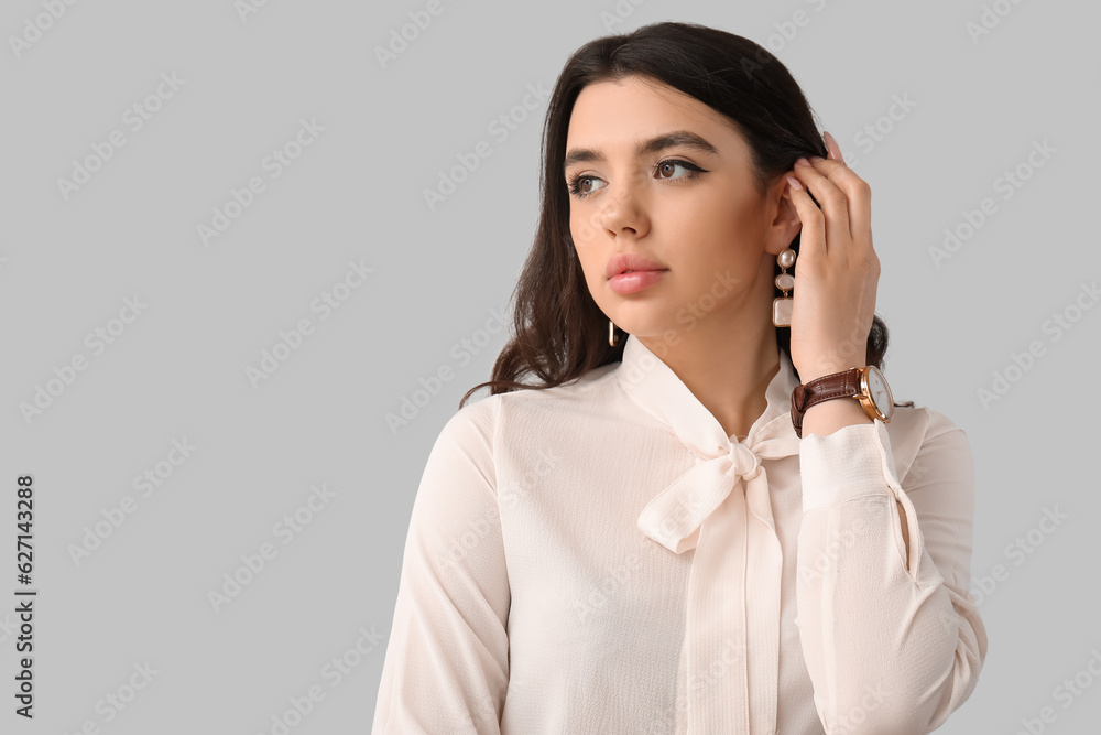 Elegant beautiful young woman with wristwatch on grey background Elegant beautiful young woman with wristwatch on grey background