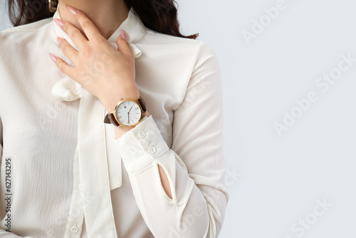 Obraz na płótnie Elegant young woman with wristwatch on grey background