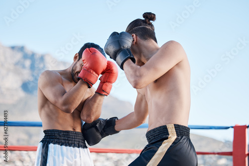 Punch, boxing match or men fighting in sports training, exercise or fist punching with strong power. Fitness action, boxers or combat fighters boxing in practice workout in ring on rooftop in city