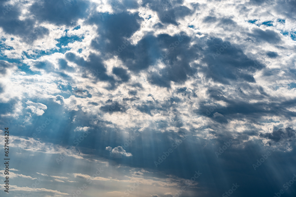 weather sun shining through dark clouds