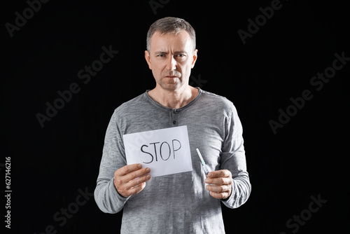 Mature drug addict holding ...