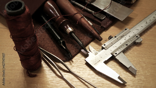 Pieces of leather and hand-tools on wooden table