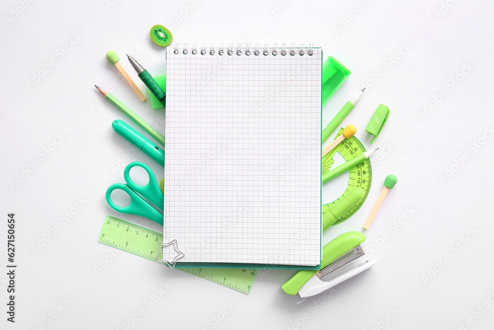Composition with blank notebook and different school stationery on white background Composition with blank notebook and different school stationery on white background