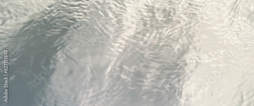 Blurred ripple water texture on white background, white water with ripples on the surface, water waves with shining pattern texture background.