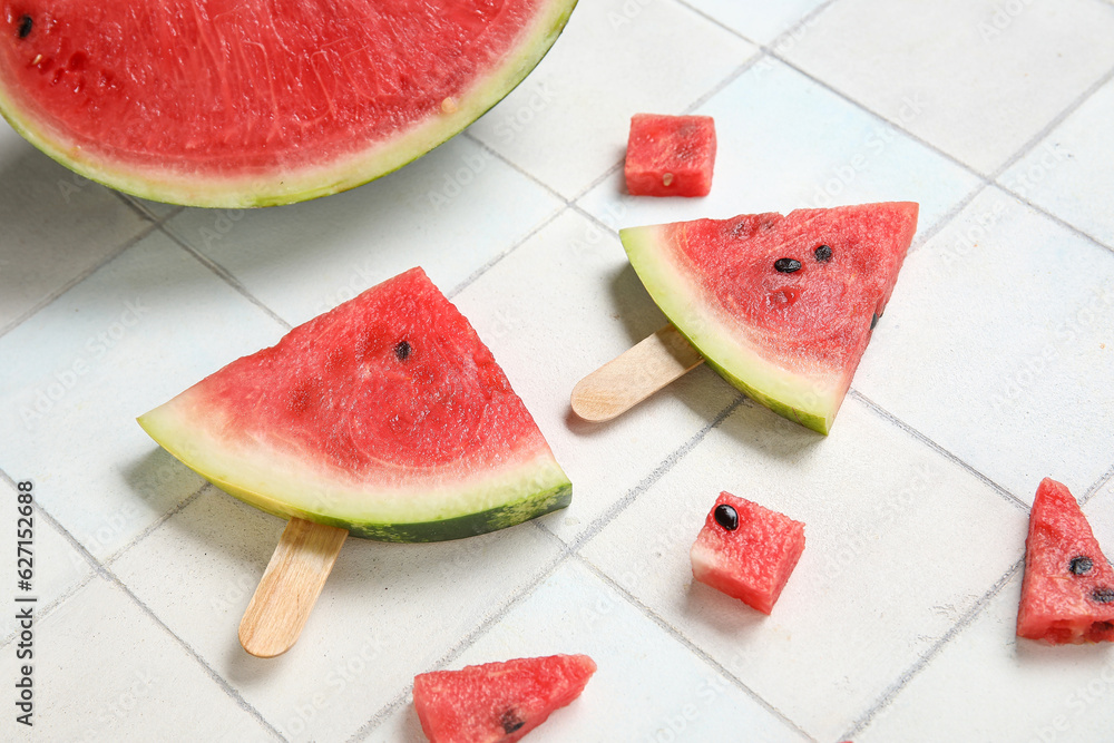 Composition with tasty watermelon sticks on light tile background, closeup