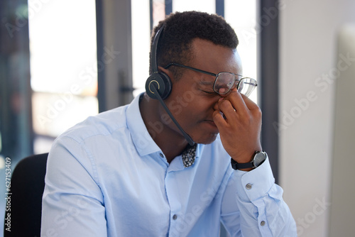 Customer support, call center burnout or black man stress over communication mistake, networking problem or anxiety. Fatigue, tired or African insurance agent, person or consultant with headache pain