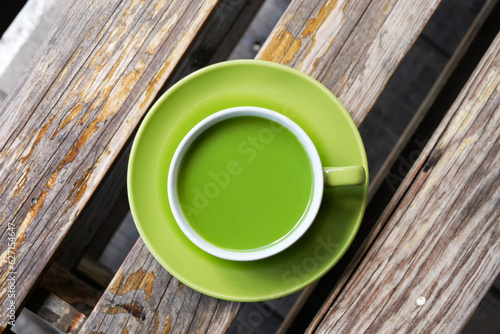 a cup of hot milk green tea on the table, top view. adding milk to green tea can result in a smoother and creamier texture with a milder flavor profile compared to plain green tea