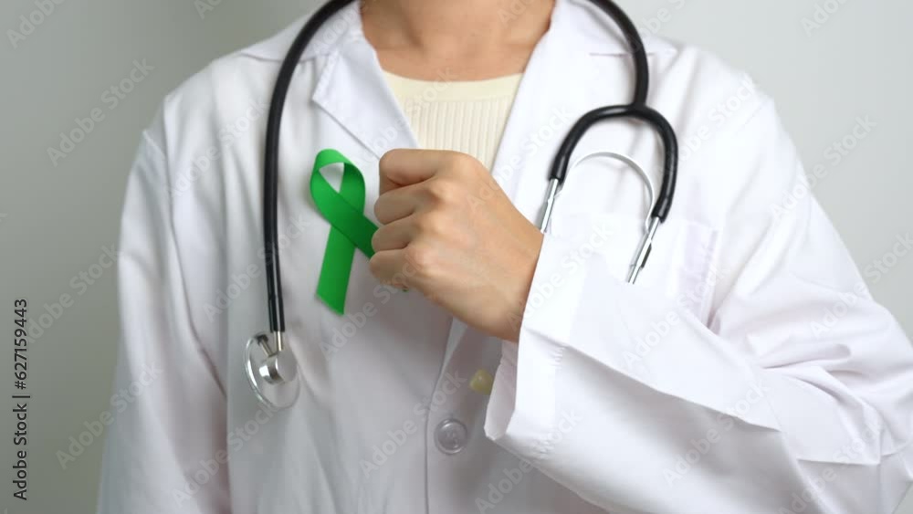 Doctor with green Ribbon for world Mental Health Day, Liver, Gallbladders, bile duct, cervical, kidney Cancer and Lymphoma Awareness month. Healthcare and world cancer day concept Doctor with green Ribbon for world Mental Health Day, Liver, Gallbladders, bile duct, cervical, kidney Cancer and Lymphoma Awareness month. Healthcare and world cancer day concept