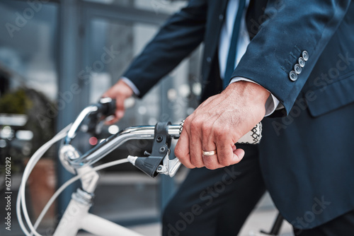 Businessman, cycling or riding with hands on bike for eco friendly travel, transport or commute to office, building or work in the city. Man, driving and bicycle for carbon neutral footprint in town
