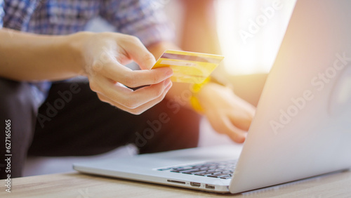 Men holding credit card and Shopping on Laptop at home