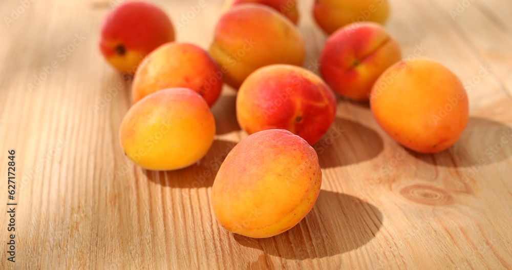 Apricots on a wooden table. Fresh fruits on a sunny day. Vegetarian food. Summer harvest. High quality photo.