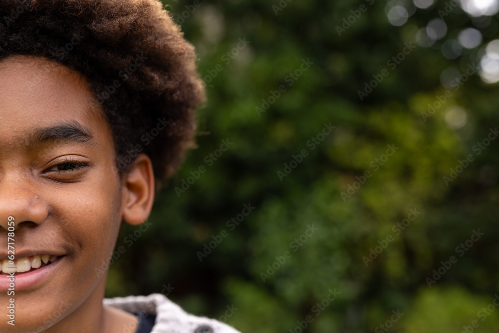 Portrait of happy african american boy smiling in garden, copy space Portrait of happy african american boy smiling in garden, copy space