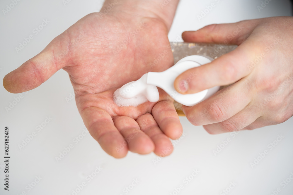 applying and rubbing the cosmetic product from the bottle into the hand applying and rubbing the cosmetic product from the bottle into the hand