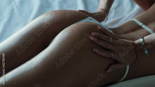 Beautiful ass of a tanned woman on a dark background. photo