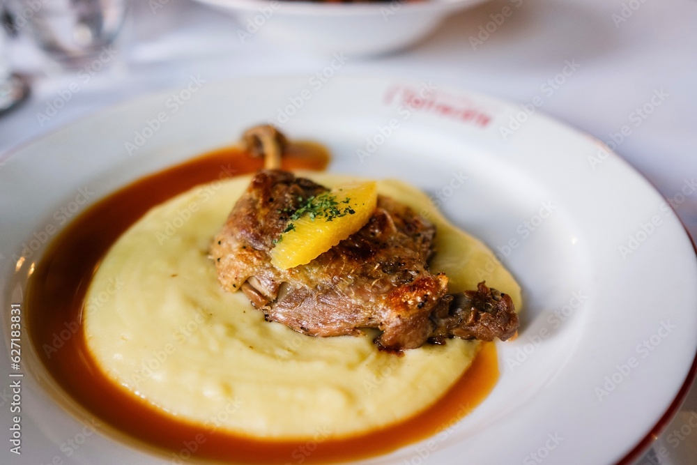 A plate of canard a l’orange (orange duck) — confit duck leg with potato purée and orange sauce — at a French bistro in Circular Quay, Sydney. New South Wales, Australia A plate of canard a l’orange (orange duck) — confit duck leg with potato purée and orange sauce — at a French bistro in Circular Quay, Sydney. New South Wales, Australia