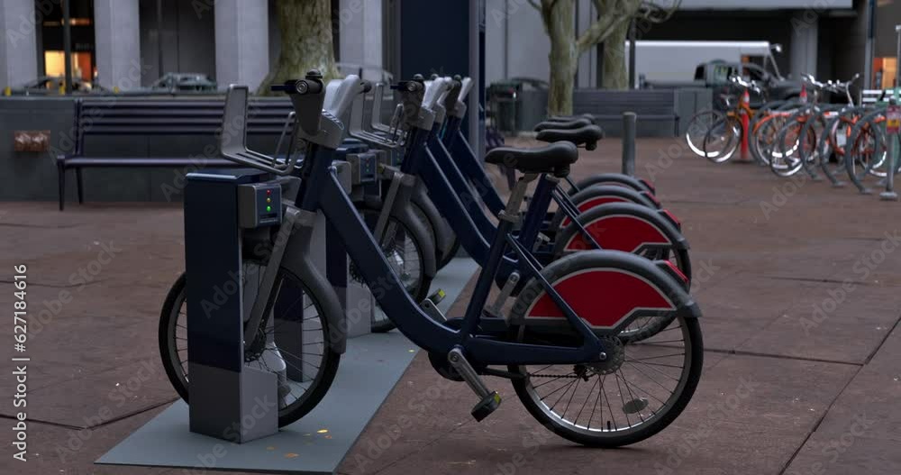 Row of Green bicycles for rent. Electric bicycle charging station. Shared electric bikes parked on city street Row of Green bicycles for rent. Electric bicycle charging station. Shared electric bikes parked on city street