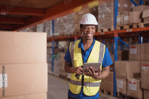 Portrait of smiling male warehouse worker using digital tablet in a warehouse