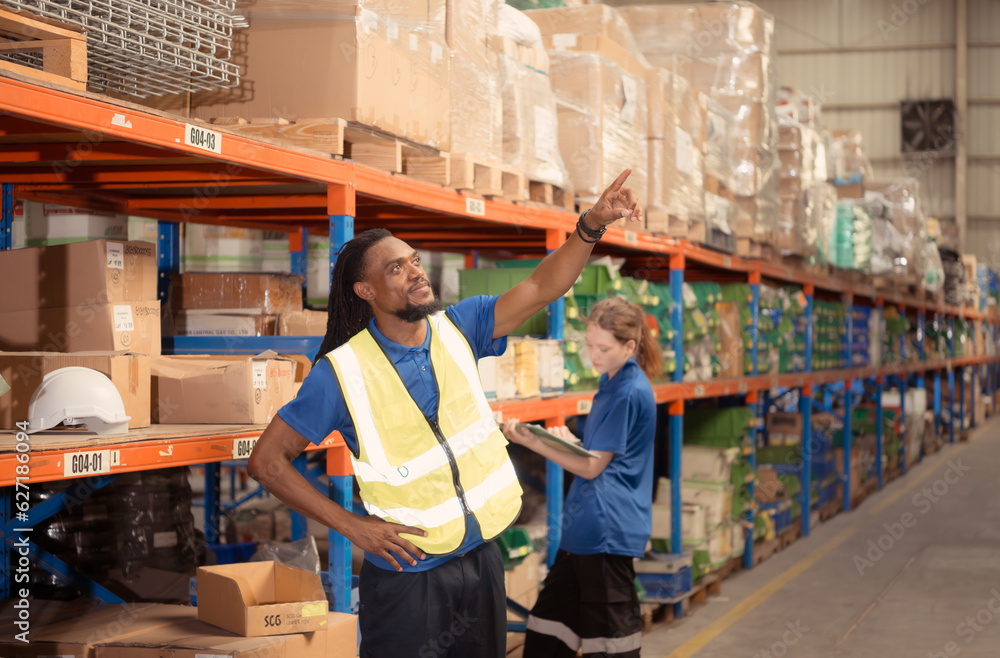 Young man and woman working together in warehouse, This is a freight transportation and distribution warehouse. Industrial and industrial workers concept