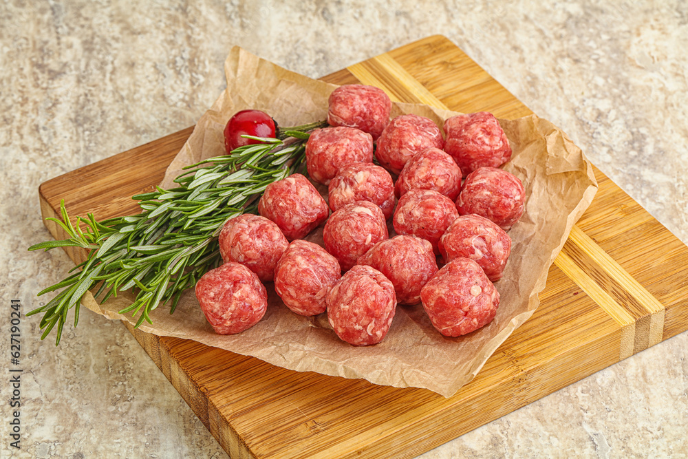 Raw uncooked beef meatballs served rosemary Raw uncooked beef meatballs served rosemary