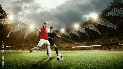 Two competitive women, football players in motion during match, game, dribbling ball at 3d arena. Open air stadium. Concept of professional sport, competition, dynamics, game, ad © master1305