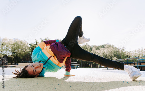 Cool asian young man dancer breakdancing outdoors