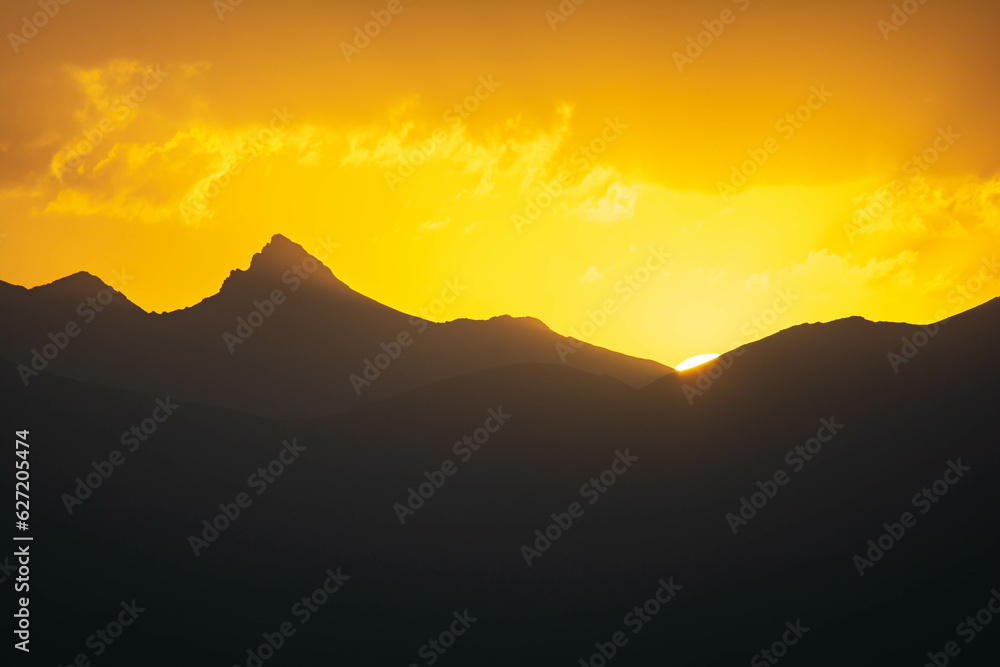 Beautiful fiery sunset. The sun goes down the mountain