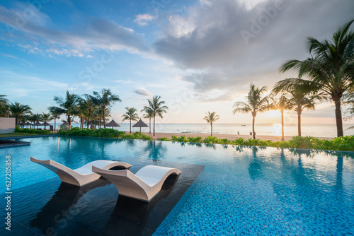 Summer vacation at poolside. Veranda decorated with deck chairs and umbrella with an ocean view