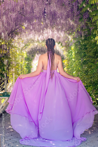 Woman wisteria lilac dress. Thoughtful happy mature woman in pur