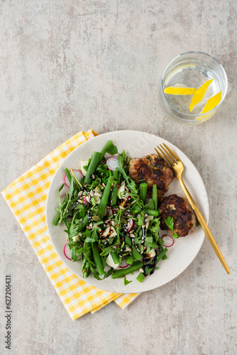 Delicious lunch or breakfast, salad with arugula and asparagus beans, radishes and various seeds, mozzarella cheese and meat patties