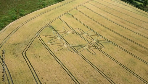 Flower design crop circle in wheat field, orbiting drone shot, United Kingdom photo