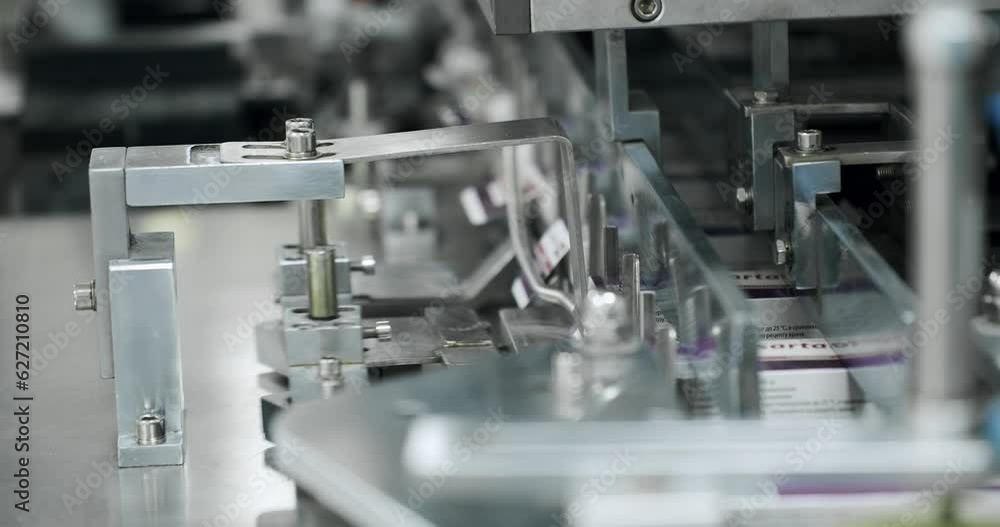 Packaged goods at automated production line. Packaging of drug. Medical factory assembly line packing medicine machine. Production line of pharmaceutical manufacturing. Packaged goods at automated production line. Packaging of drug. Medical factory assembly line packing medicine machine. Production line of pharmaceutical manufacturing.