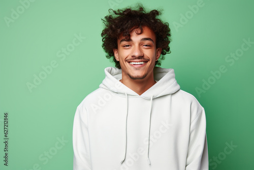 Young smiling african american man wearing blank white hoodie isolated on a green background. AI
