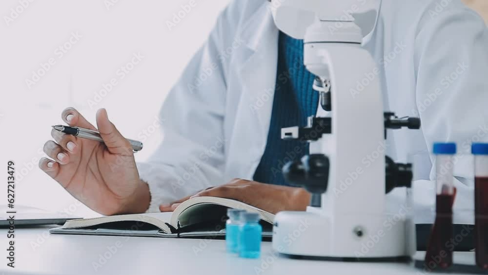 biochemical research scientist team working with microscope for coronavirus vaccine development in pharmaceutical research labolatory, selective focus biochemical research scientist team working with microscope for coronavirus vaccine development in pharmaceutical research labolatory, selective focus
