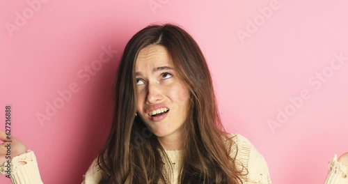 WHY! HOW! Angry frustrated brunette woman upset raising hands in indignant expression with suffer face feeling confuse don't understand asking for reasons what's wrong gesture on pink background.
