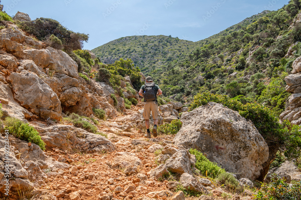 Tourist walking the hiking trail from Stavros to Katholiko Bay and Gouverneto Monastery, Stavros, Akrotiri district of the city of Chania, Crete, Greece